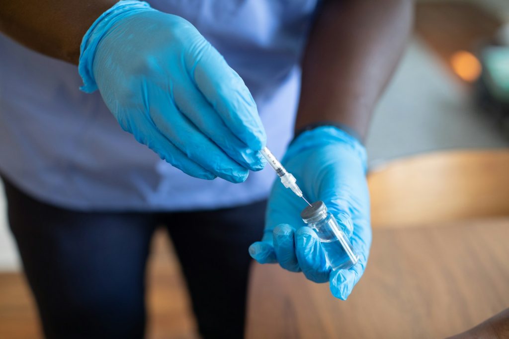 A healthcare professional preparing a Ketamine infusion in a clinical setting, showcasing the medical equipment used in the therapy